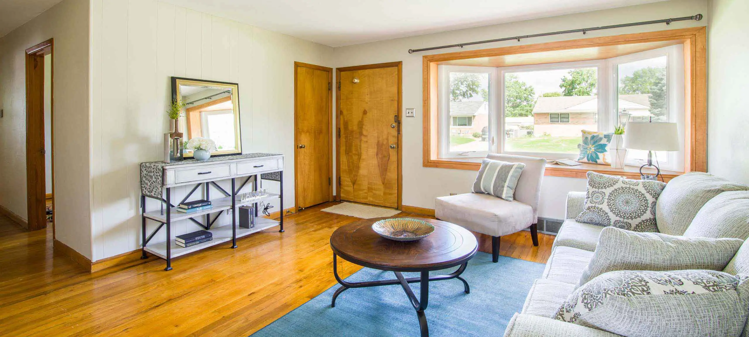 Bright and welcoming Acadia Calgary bungalow living room with large bay window, hardwood floors, and mid-century charm.